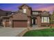Beautiful two-story home with a brick facade, attached garage, and well-manicured lawn, creating an inviting curb appeal at 3745 Spanish Oaks Trl, Castle Rock, CO 80108