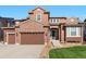 Beautiful two-story home showcasing brick and siding, an attached three-car garage, and manicured front lawn at 3745 Spanish Oaks Trl, Castle Rock, CO 80108