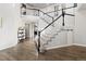 Elegant foyer showcasing a staircase with dark railing, open landing, and hardwood floors, highlighting the home's interior at 3745 Spanish Oaks Trl, Castle Rock, CO 80108