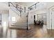 Welcoming foyer with hardwood floors, grand staircase with wrought iron railing, and open views of the dining area at 3745 Spanish Oaks Trl, Castle Rock, CO 80108