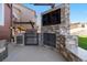 Backyard entertainment area featuring a built-in grill, stone surround television, and outdoor kitchen, creating a fantastic space at 3745 Spanish Oaks Trl, Castle Rock, CO 80108