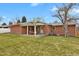 A view of the backyard featuring a covered patio, lush green lawn and well-maintained landscaping at 6620 S Foresthill St, Littleton, CO 80120