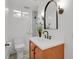 Stylish bathroom features a modern vanity, sleek mirror, and updated fixtures with a shower in the background at 6620 S Foresthill St, Littleton, CO 80120