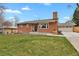 Charming brick home featuring a lush front lawn and an attached garage at 6620 S Foresthill St, Littleton, CO 80120