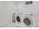 Convenient laundry room with modern washer and dryer, and stylish patterned tile flooring at 6620 S Foresthill St, Littleton, CO 80120