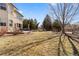 A sprawling backyard with a well-maintained lawn, mature trees, and a wooden fence at 6445 S Telluride St, Aurora, CO 80016