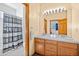 Well-lit bathroom with a double sink vanity, tiled countertop, and a shower/tub combination with striped curtain at 6445 S Telluride St, Aurora, CO 80016