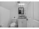 Powder room featuring a toilet, vanity with modern countertop, stylish backsplash, and overhead lighting at 6445 S Telluride St, Aurora, CO 80016