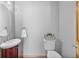 Well-lit powder room featuring a dark wood vanity, oval mirror, and white fixtures at 6445 S Telluride St, Aurora, CO 80016