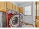 Convenient laundry room with modern washer and dryer, cabinetry, and natural light at 6445 S Telluride St, Aurora, CO 80016