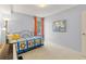 This bedroom features a colorful quilt, piano and bright light from the window at 1200 N Humboldt St # 101, Denver, CO 80218