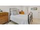 Bedroom showcasing a wrought iron bed frame, cozy carpet, dressers, and peaceful decor at 1200 N Humboldt St # 101, Denver, CO 80218