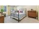 Cozy bedroom with a decorative iron bed frame, soft carpet, and dresser at 1200 N Humboldt St # 101, Denver, CO 80218