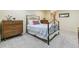 Comfortable bedroom with a decorative iron bed frame, soft carpet, and dresser at 1200 N Humboldt St # 101, Denver, CO 80218