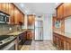 Functional kitchen featuring stainless steel appliances, wooden cabinets, tile floors, and neutral countertops at 1200 N Humboldt St # 101, Denver, CO 80218