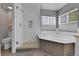Bright bathroom featuring a glass enclosed shower, soaking tub, and neutral color palette at 5394 S Gray St, Littleton, CO 80123