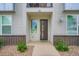 Inviting home entrance with a modern door, brick accents, and well-maintained landscaping at 8711 E Hampden Ave # 26, Denver, CO 80231