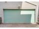 Contemporary garage door in a light teal color with house number 26 above at 8711 E Hampden Ave # 26, Denver, CO 80231