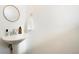 Elegant powder room with a pedestal sink, modern faucet, and a round mirror at 8711 E Hampden Ave # 26, Denver, CO 80231