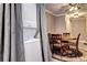 Dining area with wood table, four chairs, and a ceiling fan, with a stackable washer and dryer tucked away at 12183 W Cross Dr # 202, Littleton, CO 80127