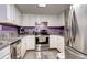 Bright kitchen with stainless steel appliances, white cabinets, and a view to the backyard for easy outdoor access at 12183 W Cross Dr # 202, Littleton, CO 80127