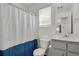 Bathroom with shower/tub combination, a blue and white shower curtain, and vanity mirror at 18233 E 51St Ave, Denver, CO 80249