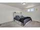 Comfortable main bedroom with gray carpet, a platform bed with storage, and modern light fixtures at 18233 E 51St Ave, Denver, CO 80249