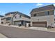 Neighborhood street view showcasing modern townhomes and attached garages at 18233 E 51St Ave, Denver, CO 80249