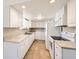 Bright kitchen with white cabinetry, light countertops, and wooden floors at 8195 Field Ct, Arvada, CO 80005