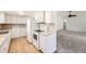 Kitchen featuring white cabinets, matching appliances, and an open layout to the living area at 8195 Field Ct, Arvada, CO 80005