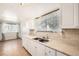 Well-lit kitchen with stainless steel sink, white cabinets, and a window providing natural light at 8195 Field Ct, Arvada, CO 80005