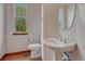Powder room featuring a pedestal sink, natural light, and wood flooring at 6556 S Versailles Ct, Aurora, CO 80016