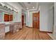 Bathroom vanity area features wood cabinets, marble counters, and wood floors at 6556 S Versailles Ct, Aurora, CO 80016