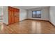 Spacious bedroom features hardwood floors, a large window, and double door closet at 6556 S Versailles Ct, Aurora, CO 80016