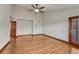 Empty bedroom with wood floors, a ceiling fan, and a door at 6556 S Versailles Ct, Aurora, CO 80016