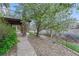 Beautiful landscaping featuring stone paver walkway and river rock flower beds surrounding mature trees at 6556 S Versailles Ct, Aurora, CO 80016