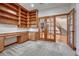Home office featuring custom built-in shelves, desk, and wood trim with stairway views at 6556 S Versailles Ct, Aurora, CO 80016
