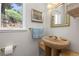 Charming bathroom featuring a pedestal sink, gold fixtures, and a window view of the outdoors at 606 Sugarloaf Mountain Rd, Boulder, CO 80302
