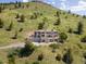 Elegant multi-story home nestled on a hillside, surrounded by lush greenery at 606 Sugarloaf Mountain Rd, Boulder, CO 80302