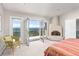 Main bedroom featuring a kiva fireplace, French doors to a private balcony with mountain views at 606 Sugarloaf Mountain Rd, Boulder, CO 80302