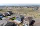 Aerial view of backyard with patio, play equipment, and outdoor seating, situated within a neighborhood with natural landscaping at 902 William Way, Brighton, CO 80603