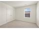 Bright bedroom featuring a neutral carpet, window, and double door closet at 902 William Way, Brighton, CO 80603