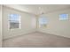 Spacious bedroom with three large windows and neutral colored carpeting at 902 William Way, Brighton, CO 80603