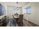 Bright dining room features a modern chandelier and views of the lush landscaping at 902 William Way, Brighton, CO 80603