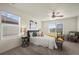 Well-lit bedroom features a ceiling fan, windows, and a comfortable bed with decorative pillows at 902 William Way, Brighton, CO 80603