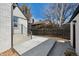 The house's backyard featuring a concrete patio surrounded by a wooden fence and various plants and trees at 4022 E 17Th Avenue Pkwy, Denver, CO 80220