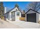 Home exterior with white brick, black trim, garage, and concrete driveway at 4022 E 17Th Avenue Pkwy, Denver, CO 80220