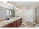 Bathroom featuring double vanity, tile countertops, and shower with glass enclosure at 15715 Carob Cir, Parker, CO 80134