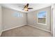 This bedroom features neutral walls, a ceiling fan, carpeted floors, and multiple windows for natural light at 15715 Carob Cir, Parker, CO 80134