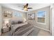 This bedroom is staged with a queen bed, side tables, art, shelves, and a ceiling fan at 15715 Carob Cir, Parker, CO 80134